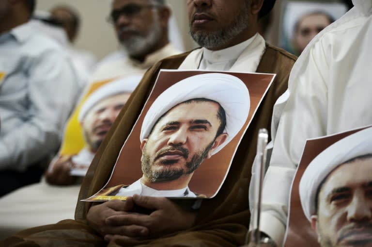 Bahraini men hold placards bearing the portrait of Sheikh Ali Salman, head of the Shiite opposition movement Al-Wefaq, during a protest on May 29, 2016 against his arrest