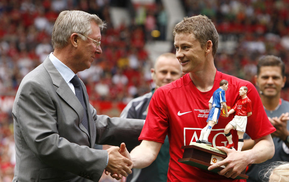 FILE - In this Saturday Aug. 2, 2008 file photo Manchester United's Ole Gunnar Solskjaer, right, shakes hands with manager Sir Alex Ferguson before his testimonial soccer match against Espanyol at Old Trafford Stadium, Manchester, England. (AP Photo/Jon Super, File)