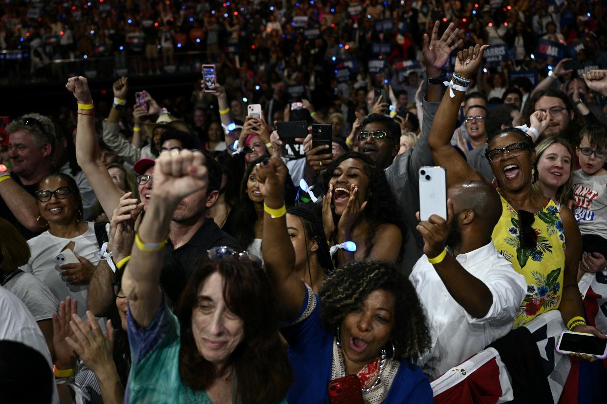 Supporters cheer as US Vice President and 2024 Democratic presidential candidate Kamala Harris and her running mate Minnesota Gorvernor Tim Walz speak at Temple University's Liacouras Center in Philadelphia, Pennsylvania.