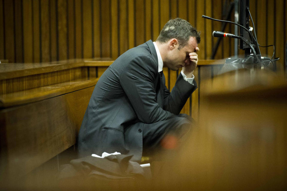 Oscar Pistorius, puts his hand to his head while listening to cross questioning about the events surrounding the shooting death of his girlfriend Reeva Steenkamp, during his trial in Pretoria, South Africa, Friday, March 7, 2014. Pistorius is charged with murder for the shooting death of Steenkamp, on Valentines Day in 2013. (AP Photo/Theana Breugem, Pool)