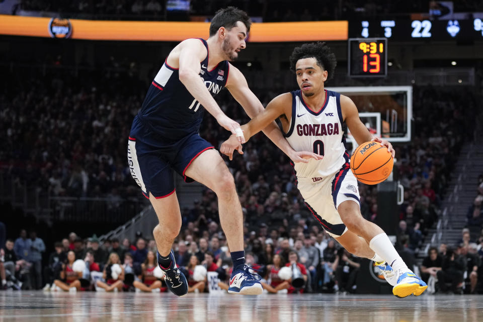 Gonzaga guard Ryan Nembhard (0) drives against UConn forward Alex Karaban (11) during the first half of an NCAA college basketball game Friday, Dec. 15, 2023, in Seattle. (AP Photo/Lindsey Wasson)