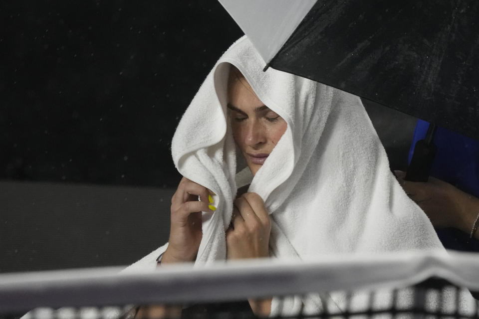 Aryna Sabalenka, of Belarus, takes cover from the rain during a women's singles match against Elena Rybakina, of Kazakhstan, at the WTA Finals tennis championships, in Cancun, Mexico, Thursday, Nov. 2, 2023. (AP Photo/Fernando Llano)