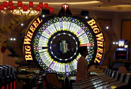 A man walks past the Big Wheel inside a new casino following the completion of the second phrase of construction at the Galaxy Macau resort in Macau, China May 26, 2015, one day before its opening. REUTERS/Bobby Yip