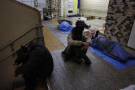 In this Thursday, Jan. 9, 2020, photo, homeless people sleep on the concrete floor of Shinjuku Station, in Tokyo. The dozens of homeless people sleeping rough in shuttered Tokyo subway stations worry that with Japan's image at stake authorities will force them to move ahead of the Olympics. (AP Photo/Jae C. Hong)
