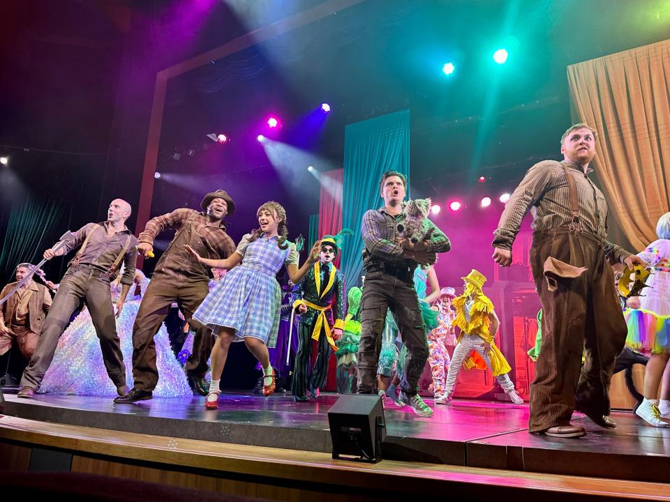 Performers in "Wizard of Oz" costumes performing on stage.