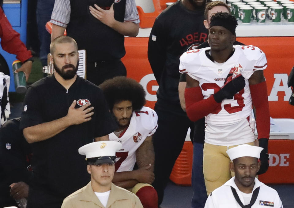 FILE - In this Thursday, Sept. 1, 2016 file photo, San Francisco 49ers quarterback Colin Kaepernick, middle, kneels during the national anthem before the team's NFL preseason football game against the San Diego Chargers, in San Diego. When Kaepernick took a knee during the national anthem to take a stand against police brutality, racial injustice and social inequality, he was vilified by people who considered it an offense against the country, the flag and the military. Nearly four years later, it seems more people are starting to side with Kaepernick’s peaceful protest and now are calling out those who don’t understand the intent behind his action. (AP Photo/Chris Carlson, File)