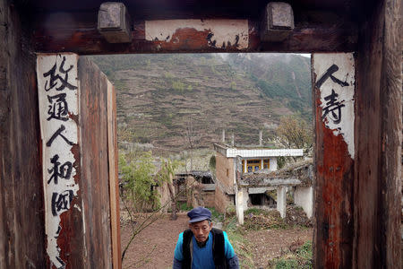 Surviving villager Ma Qingan walks through doors after leaving his old house at a minority village which was badly damaged in the 2008 Sichuan earthquake in Wenchuan county, Sichuan province, China, April 5, 2018. REUTERS/Jason Lee