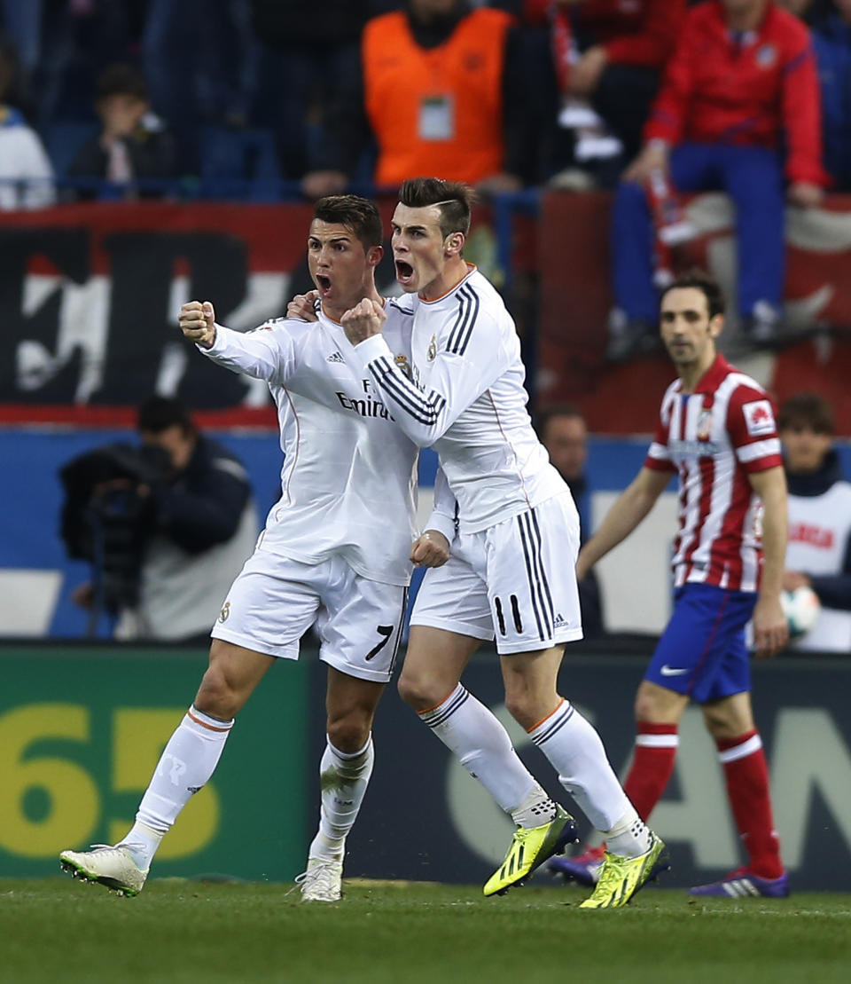 Real's Cristiano Ronaldo, left, celebrates his goal with teammate Gareth Bale, center, during a Spanish La Liga soccer match between Atletico de Madrid and Real Madrid at the Vicente Calderon stadium in Madrid, Spain, Sunday, March 2, 2014. (AP Photo/Andres Kudacki)