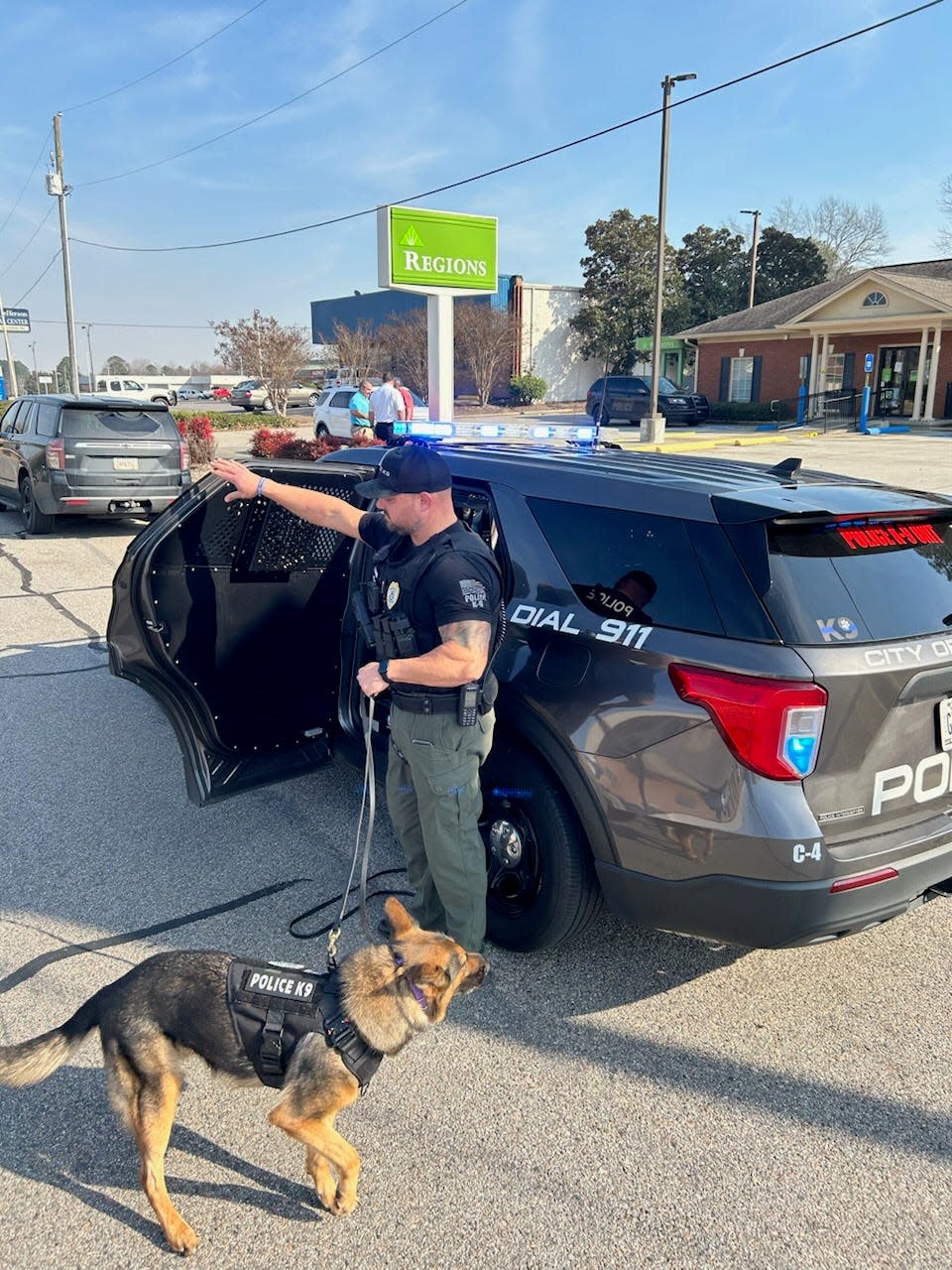 Wrens Police K9 tracking dog Harlowe gets out of a patrol car to begin looking for leads at the Regions Bank shortly after a robbery at that location.