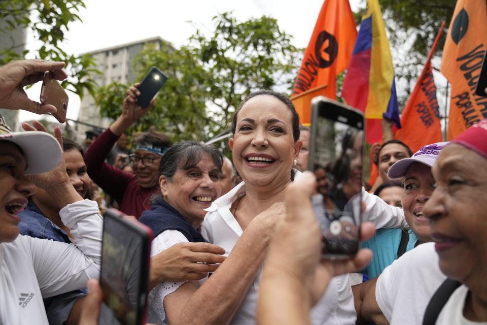 La líder opositora y aspirante a la presidencia de Venezuela, María Corina Machado, que fue inhabilitada para ejercer cargos públicos, recibe abrazos de sus seguidores durante un mitin en el que les pidió que mantengan la fe, en San Antonio, Venezuela, el 17 de abril de 2024. Las elecciones presidenciales de Venezuela están previstas para el 28 de julio. (AP Foto/Ariana Cubillos)