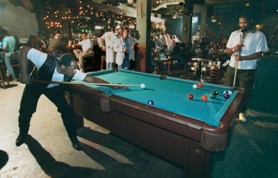Rose’s Bar regular Sam Pink shoots pool with the club’s manager and booking agent Jacques Milhomme on March 23, 1995. Raul Rubiera/The Miami Herald