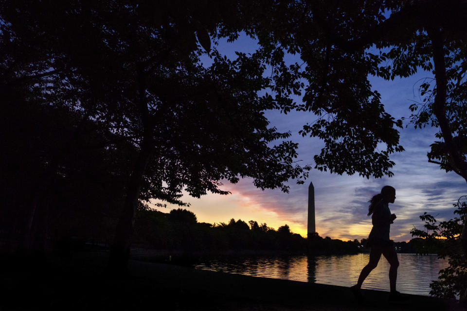 FILE - In this July 25, 2017 file photo, an early morning runner is silhouetted against the rising sun at the Tidal Basin in Washington. Recent killings of women who were attacked while engaged in the sports they love have raised questions about how women can defend themselves and why they must be ready to fight off attackers in the first place. (AP Photo/J. David Ake, File)