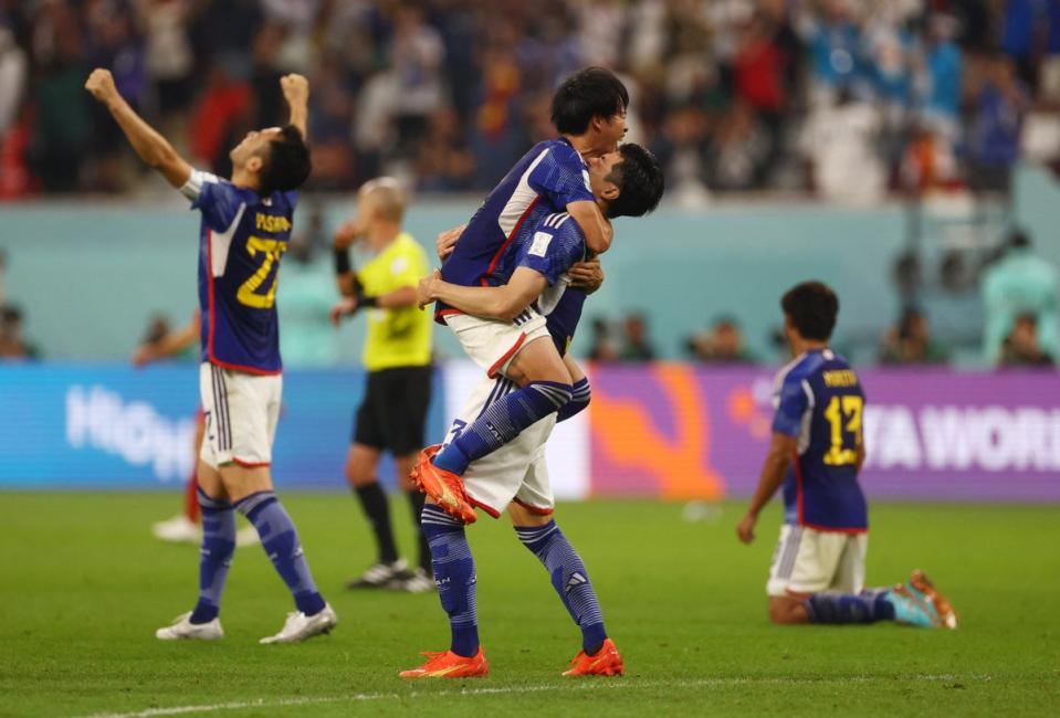 Japan celebrate after beating Spain on Thursday night (REUTERS)
