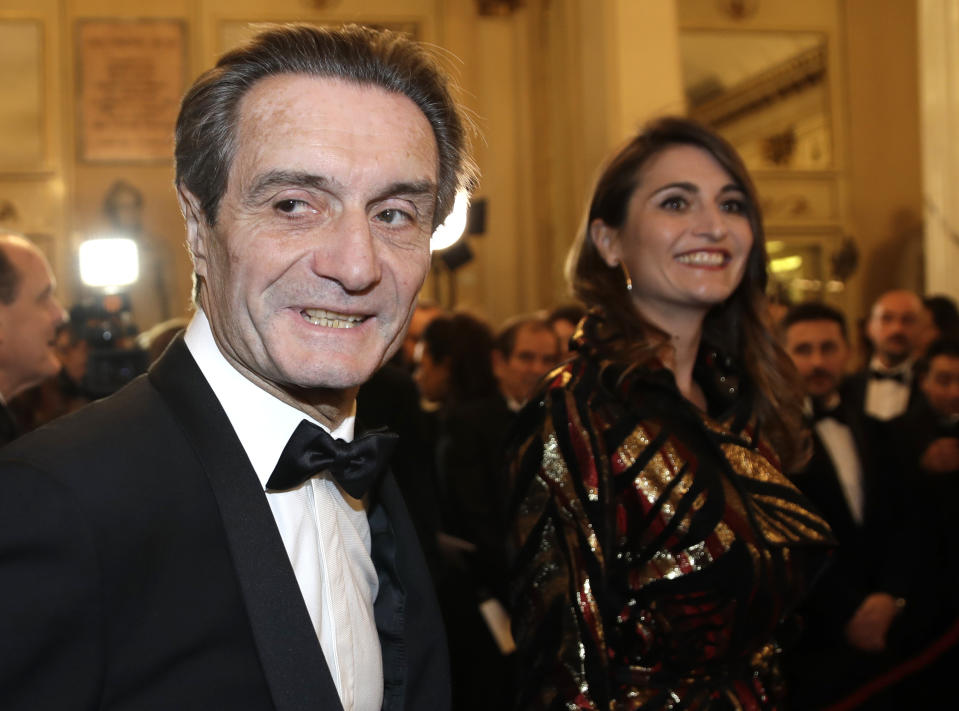 Lombardy region president Attilio Fontana arrives daughter Maria Cristina flanked by his for the gala premiere of La Scala opera house, in Milan, Italy, Saturday, Dec. 7, 2019. Milan's storied La Scala opens its 2019-2020 season on Saturday with Puccini's "Tosca," which stars Russian soprano Anna Netrebko as the object of unwanted sexual attention from a powerful authority figure. (AP Photo/Luca Bruno)