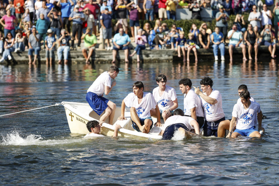 Cross divers swim towards a dinghy as they get ready during the annual cross dive in the Spring Bayou, part of the Epiphany celebration on Saturday, Jan. 6, 2024, in Tarpon Springs, Fla. (Jefferee Woo/Tampa Bay Times via AP)