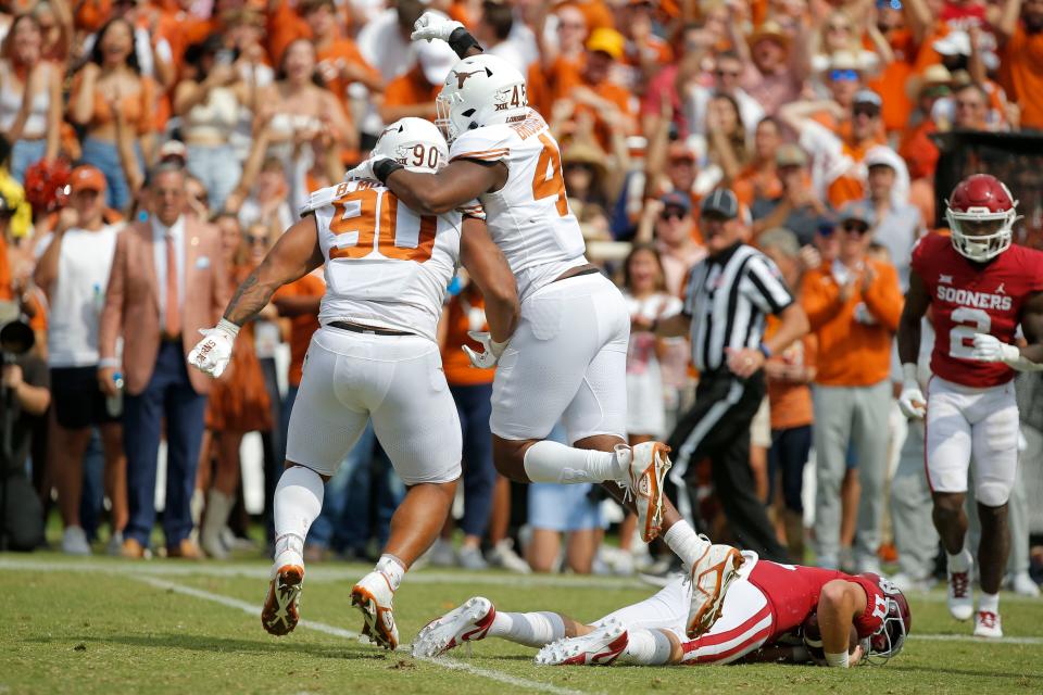 Texas defensive linemen Byron Murphy II, left, and Vernon Broughton celebrate after sacking Oklahoma quarterback Davis Beville last year at the Cotton Bowl. Texas won 49-0.