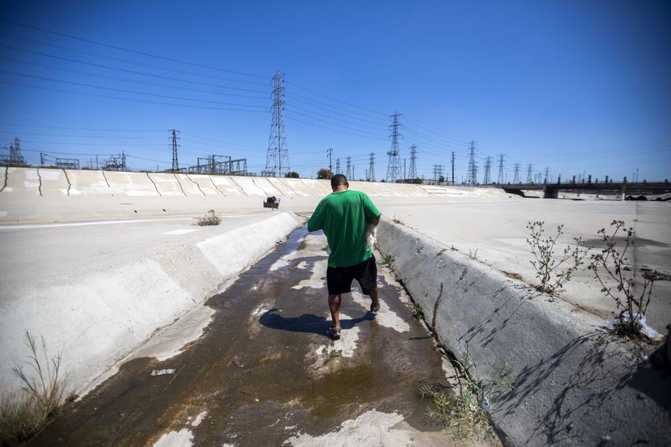 A man walks along an outflow drain