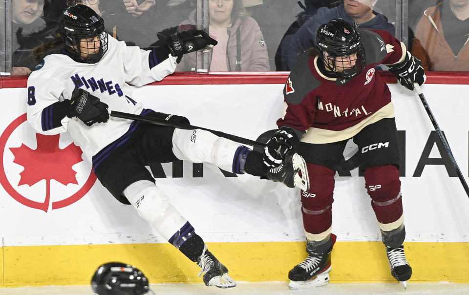 Minnesota's Brittyn Fleming (18) is checked by Montreal's Catherine Daoust (4) during the third period of a PWHL hockey game in Laval, Quebec, Sunday, Feb. 18, 2024. (Graham Hughes/The Canadian Press via AP)