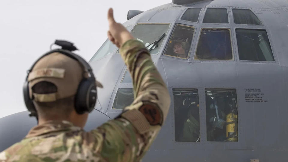 U.S. Air Force Capt. Taylor Drolshagen, 41st Expeditionary Electronic Combat Squadron pilot, signals to Airman 1st Class Logan Romo, 41st EECS airborne maintenance technician, as she starts the engine of an EC-130H Compass Call aircraft in preparation for a large force employment exercise at Al Dhafra Air Base, United Arab Emirates, July 13, 2021. (Master Sgt. Wolfram M. Stumpf/Air Force)