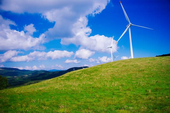 Wind turbines on a grassy hill.