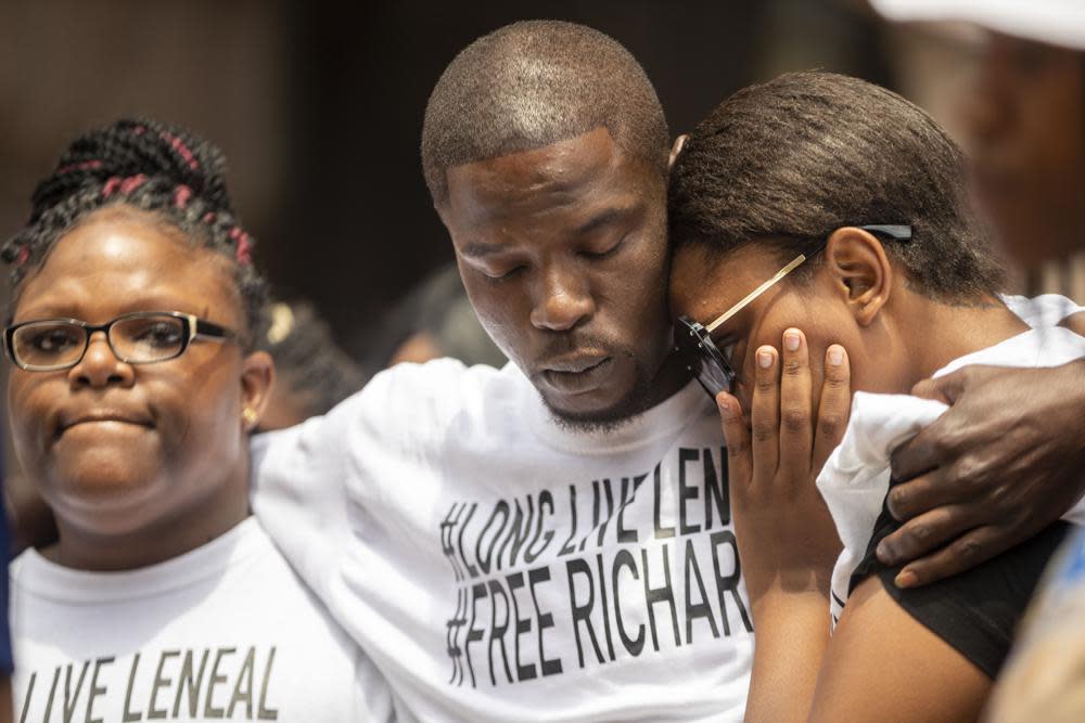 In the July 9, 2021 file photo, from left, Cheryl Frazier, sister of Leneal Frazier; Orlando Frazier, brother of Leneal; and Jamie Bradford,, daughter of Leneal, embrace one another during a news conference outside of City Hall in Minneapolis. (Antranik Tavitian/Star Tribune via AP File)