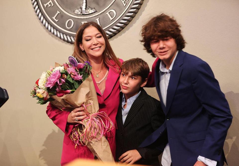 Pedro, en el extremo derecho, y Pablo Caviedes posando con su madre, Sabina Covo, después de prestar juramento ante la juez Lody Jean durante su ceremonia de juramentación en el Ayuntamiento de la ciudad.