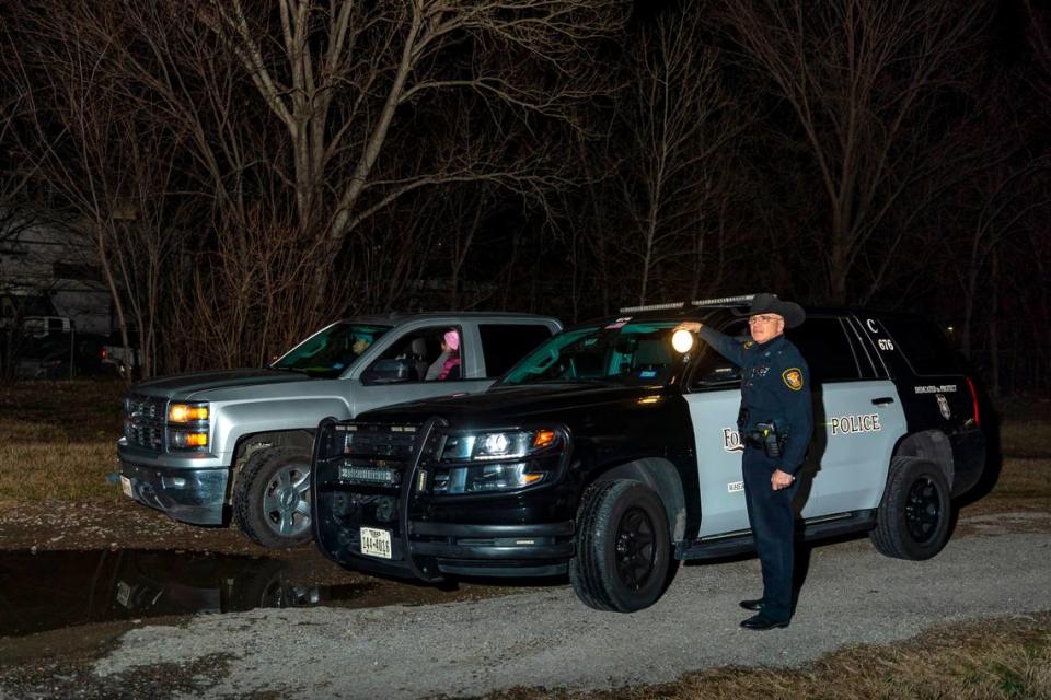 FWPD officer Ron Andriotto shines a searchlight into brush to look for sleeping sites during the Point in Time Count on Thursday, Jan. 27, 2023, in Fort Worth.