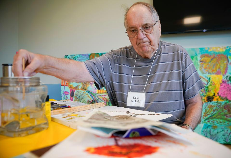 Dale Sickels wets his brush and looks at a reference photo during an art session at Baker Senior Center Naples in North Naples on Monday, Jan. 23, 2023.