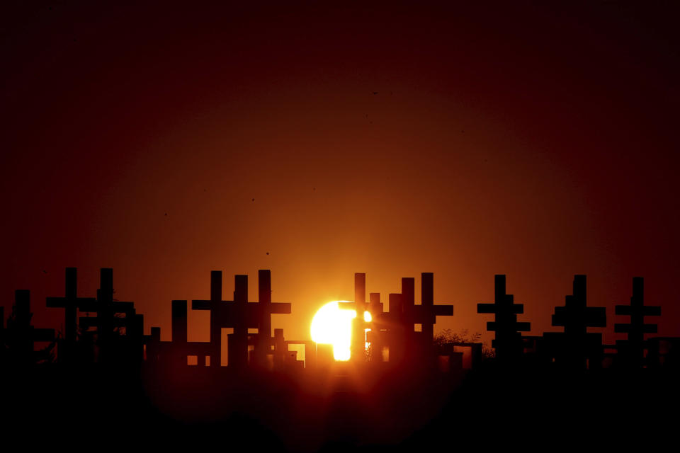 The graves of soldiers killed in the 1974 Turkish invasion of Cyprus during a unset at the Tymvos Macedonitissas military cemetery during the 45th anniversary in the divided capital of Nicosia, Cyprus, Friday, July 19, 2019. Some thousands of Greek and Cypriot soldiers were killed in 1974 during the Turkish invasion and subsequent occupation of the northern part of the island of Cyprus. (AP Photo/Petros Karadjias)