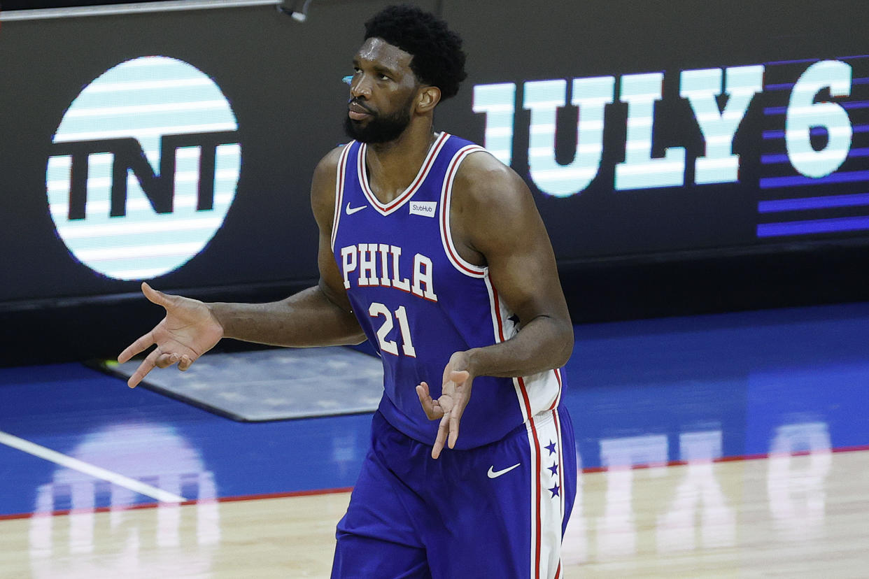 Joel Embiid shrugs his arms during a game.