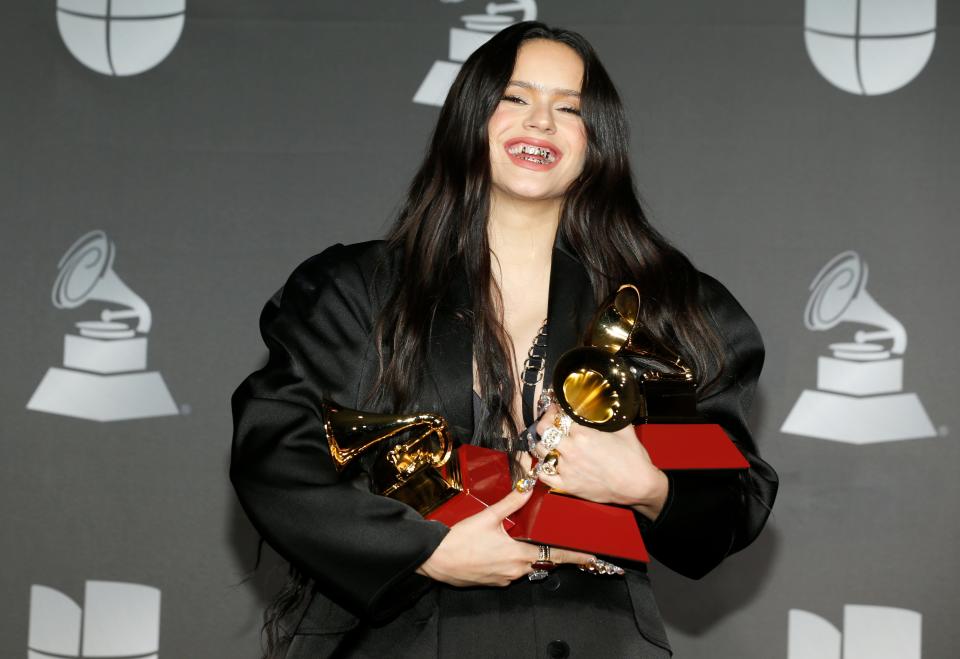 Rosalía poses with her Latin Grammys after winning three awards on Thursday night.