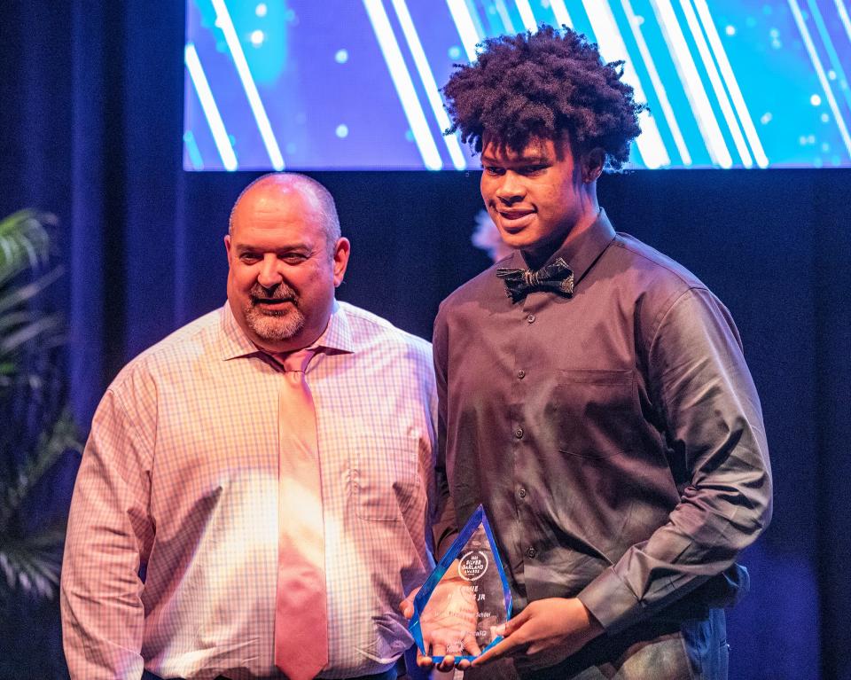 Jamie Phillips Jr., a student at Winter Haven High School receives the Silver Garland Award in the Athletics category from Polk County schools Superintendent Frederick Heid during a ceremony at the AdventHealth Fieldhouse in Winter Haven on Thursday.