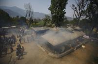 Smoke rises during the cremation ceremony of Nepali Sherpa climbers, who lost their lives during an avalanche at Mount Everest last Friday, in Kathmandu April 21, 2014. (REUTERS/Navesh Chitrakar)