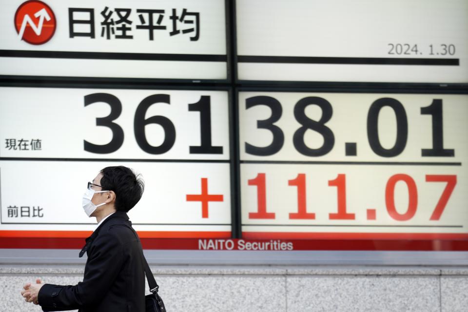 A person walks in front of an electronic stock board showing Japan's Nikkei 225 index at a securities firm Tuesday, Jan. 30, 2024, in Tokyo. Asian shares were mixed on Tuesday, with Hong Kong and Shanghai leading declines, ahead of a decision by the Federal Reserve this week on interest rates. (AP Photo/Eugene Hoshiko)