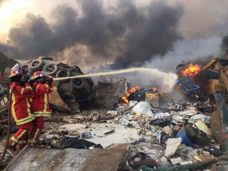 Firefighters spray water at a fire after an explosion was heard in Beirut