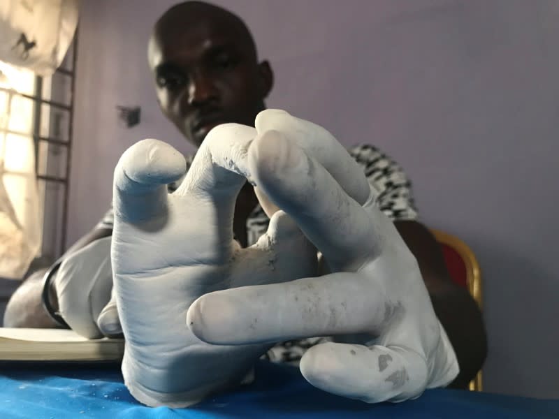 John Amanam works on a prosthetic hand at his company in Uyo