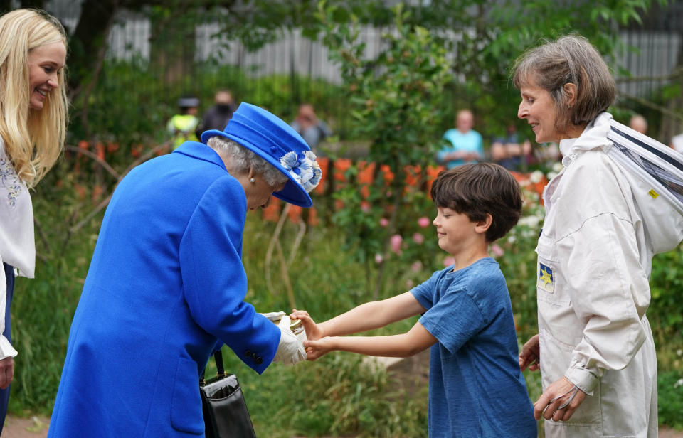 Britain's Queen Elizabeth II is given a jar of honey during a visit to The Childrens Wood Project in Glasgow on June 30, 2021, as part of her traditional trip to Scotland for Holyrood Week. (Photo by Andrew Milligan / POOL / AFP) (Photo by ANDREW MILLIGAN/POOL/AFP via Getty Images)