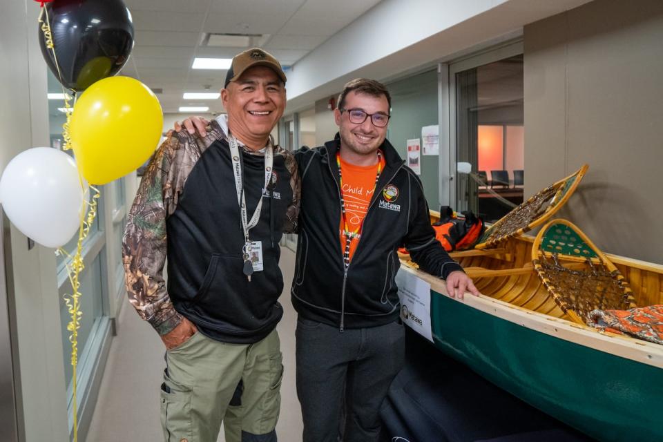 Eddy Baxter and Joseph Willis, staff members at the Matawa Education and Care Centre in Thunder Bay, Ont., show off the canoe that students are building, which is currently a work in process. The project is part of the centre's land-based program.