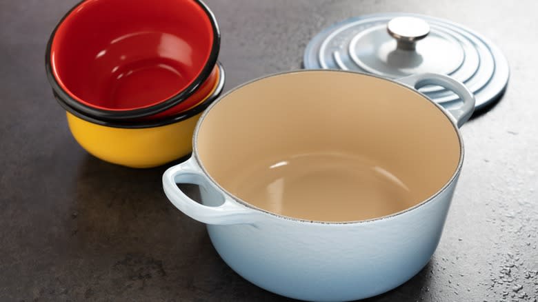 Empty Dutch oven beside bowls 