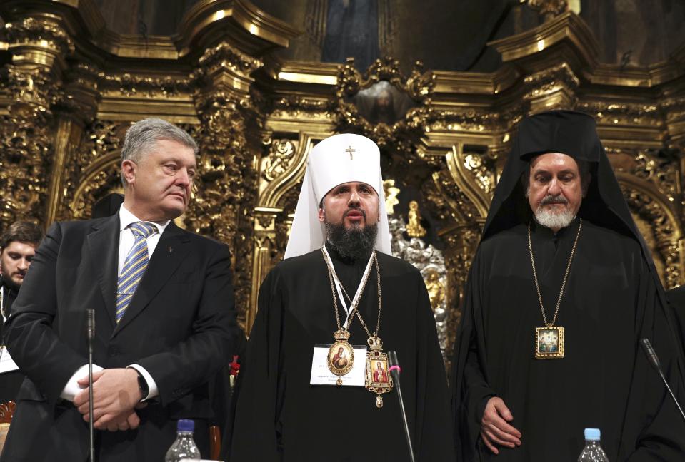 Ukrainian President Petro Poroshenko, left, the new head of Ukrainian Orthodox church Metropolitan Epiphanius, center, and Metropolitan Emmanuel attend a closed-door synod of three Ukrainian Orthodox churches to approve the charter for a unified church and to elect leadership in the St. Sophia Cathedral in Kiev, Ukraine, Saturday, Dec. 15, 2018. (Mikhail Palinchak, Ukrainian Presidential Press Service/Pool Photo via AP)