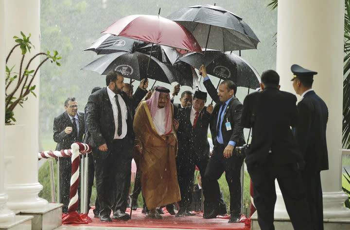 King Salman and Indonesian President Joko Widodo walk under umbrellas during heavy rain at the presidential palace in Bogor, West Java, Indonesia (Credit: AP/REX/Shutterstock)