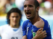 Italy's Giorgio Chiellini shows his shoulder, claiming he was bitten by Uruguay's Luis Suarez, during their 2014 World Cup Group D soccer match at the Dunas arena in Natal June 24, 2014. REUTERS/Tony Gentile (BRAZIL - Tags: SOCCER SPORT WORLD CUP TPX IMAGES OF THE DAY)