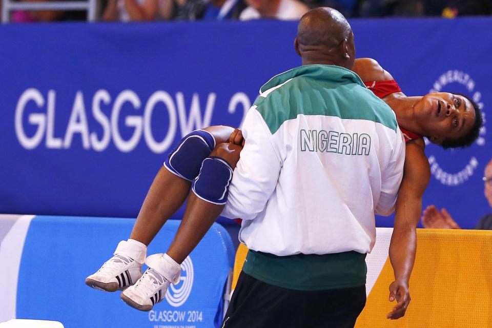 Ifeoma Nwoye of Nigeria is carried away by her coach after she lost her women's freestyle 55kg wrestling semi-final to Brittanee Laverdure of Canada at the 2014 Commonwealth Games in Glasgow, Scotland, in this July 31, 2014 file photo. REUTERS/Andrew Winning/Files (BRITAIN - Tags: SPORT WRESTLING TPX IMAGES OF THE DAY)