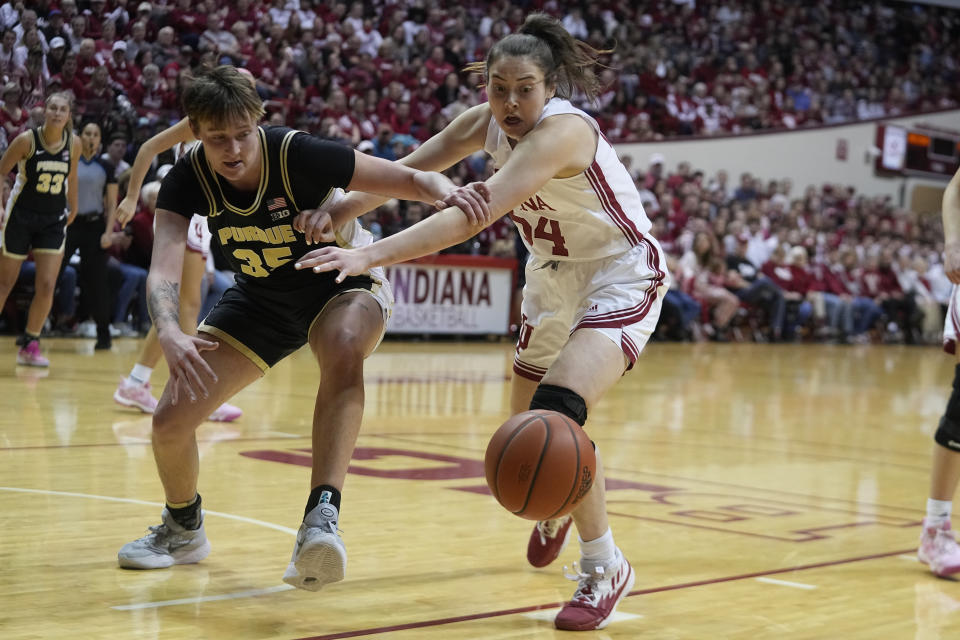 Purdue's Rickie Woltman (35) and Indiana's Mackenzie Holmes (54) battle for a loose ball during the first half of an NCAA college basketball game, Sunday, Feb. 19, 2023, in Bloomington, Ind. (AP Photo/Darron Cummings)