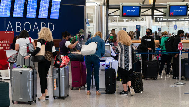 Passengers wearing protective masks check in at the Delta Air Lines ticket counter at Hartsfield-Jackson Atlanta International Airport in Atlanta, on Wednesday, April 7, 2021. U.S. airlines are bringing back more pilots as they prepare for an expected travel rebound. / Credit: Elijah Nouvelage/Bloomberg via Getty Images