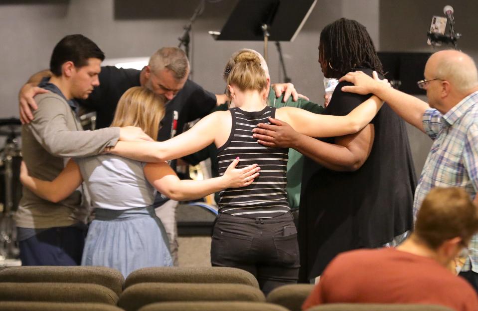 Alliance Christian Center's Praise Team and the church's pastor Kirk Martin, right, take part in a prayor circle before taking the stage for praise songs Thursday, May 2, 2024, at the National Day of Prayer program at Alliance Christian Center.