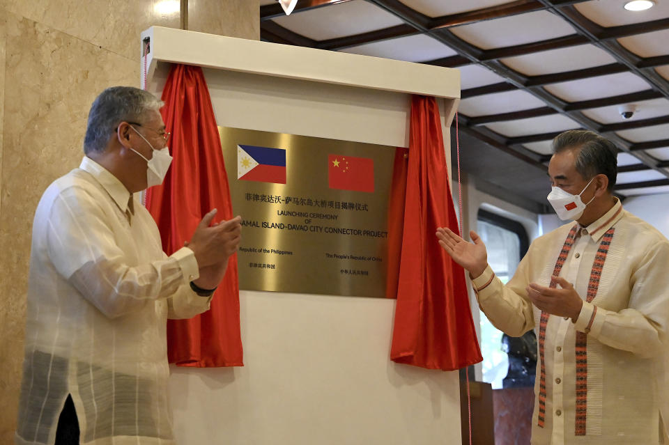 Philippine Foreign Affairs Secretary Enrique Manalo, left, and Chinese Foreign Minister Wang Yi unveil a project marker at the Department of Foreign Affairs in Manila, Philippines on Wednesday, July 6, 2022. (Jam Sta Rosa/Pool Photo via AP)