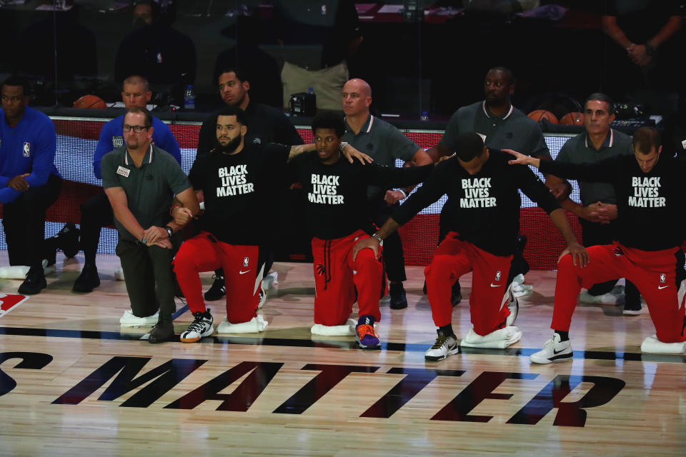 LAKE BUENA VISTA, FLORIDA - SEPTEMBER 09:  Members of the Toronto Raptors kneel during the national anthem before Game Six of the second round of the 2020 NBA Playoffs at ESPN Wide World of Sports Complex on September 9, 2020 in Lake Buena Vista, Florida.  NOTE TO USER: User expressly acknowledges and agrees that, by downloading and or using this photograph, User is consenting to the terms and conditions of the Getty Images License Agreement. (Photo by Kim Klement-Pool/Getty Images)