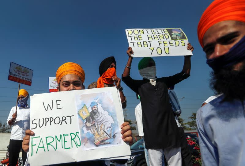 People hold placards during a nationwide strike to protest against newly passed farm bills, in Mumbai