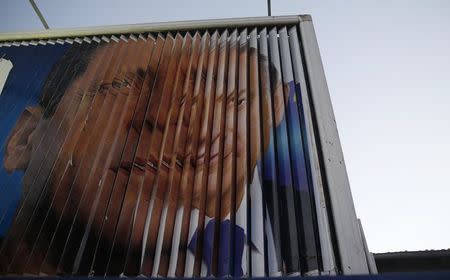 Israel's Prime Minister Benjamin Netanyahu (R) and Isaac Herzog, co-leader of the centre-left Zionist Union, are pictured together as campaign billboards rotate in Tel Aviv March 15, 2015. REUTERS/Baz Ratner